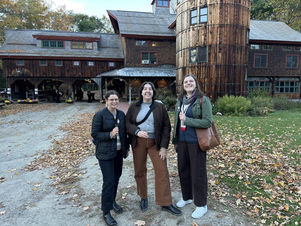 Three people holding forks at a farm dinner