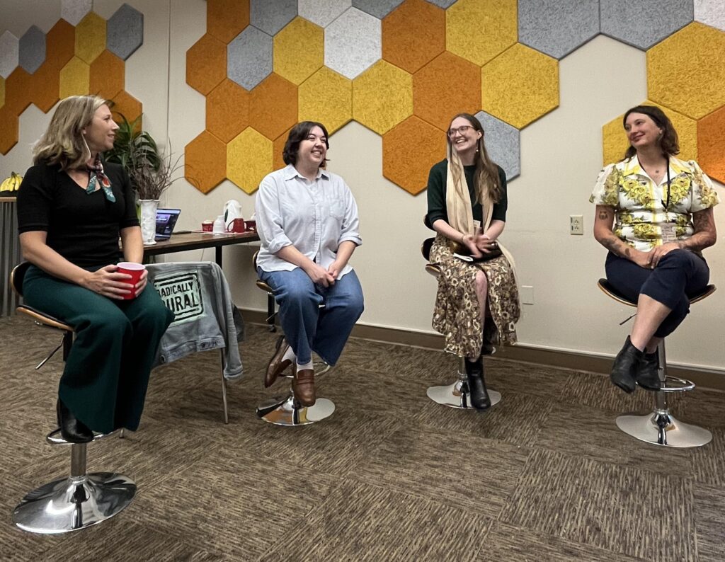 Four people sitting on stools talking